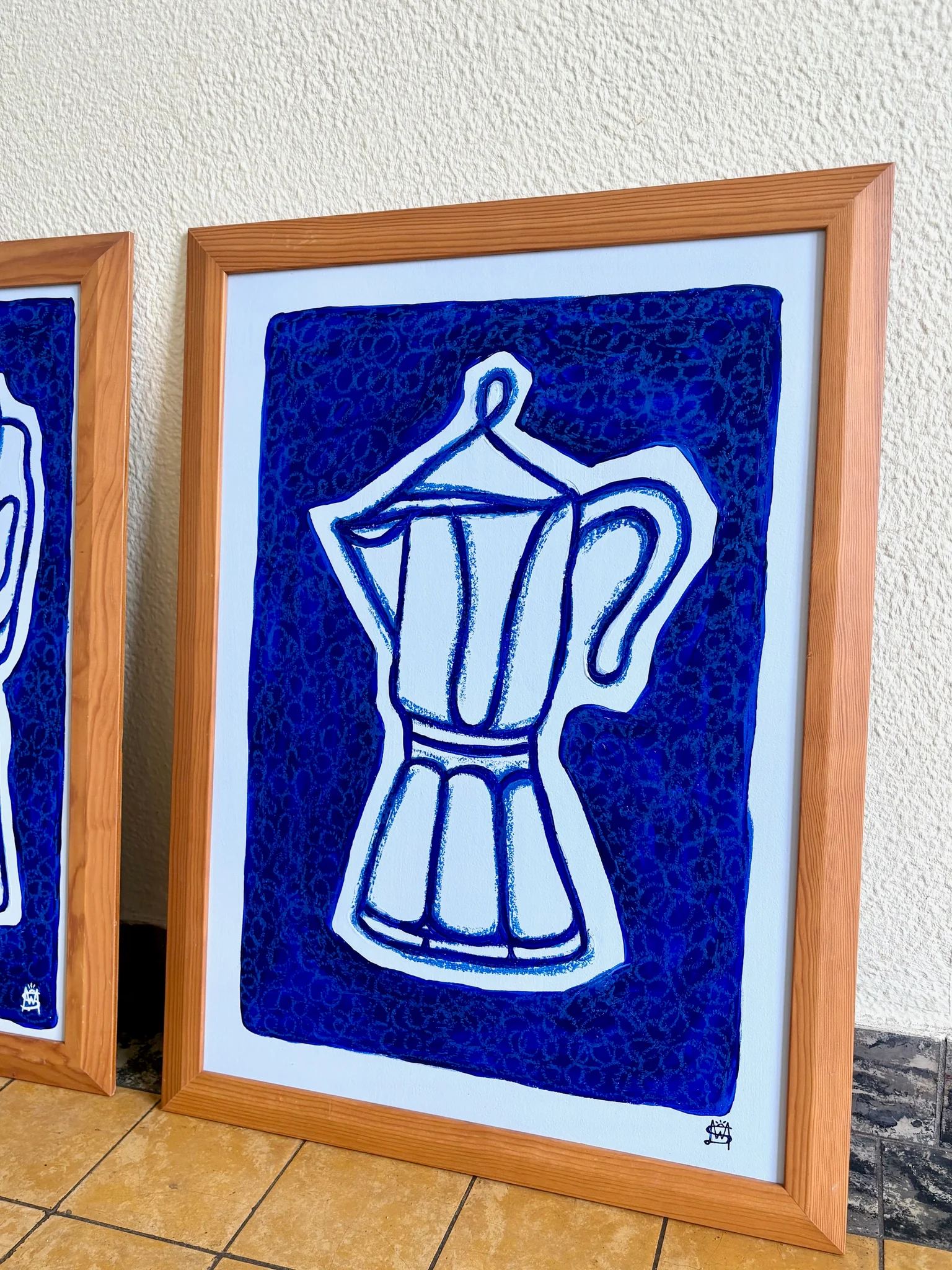 Ingelijst schilderij van een percolator in blauwe en witte tinten.
